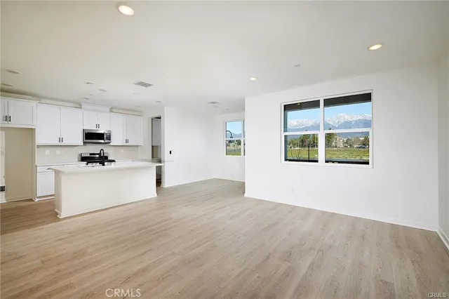 a view of a kitchen with wooden floor and windows