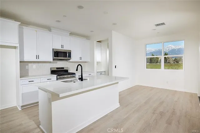 a kitchen with stainless steel appliances a stove refrigerator sink and microwave