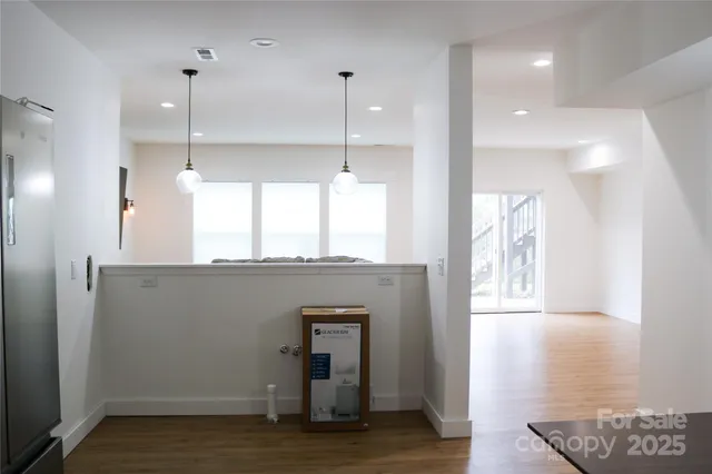 a view of a kitchen with a window and wooden floor