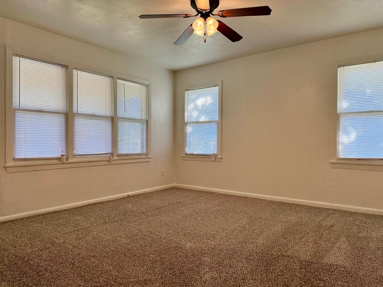 4001 32nd Street Lubbock, TX 79410 - Photo 8 of 21 an empty room with windows and fan