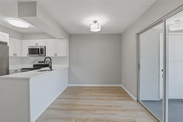 a kitchen with granite countertop a sink cabinets and wooden floor
