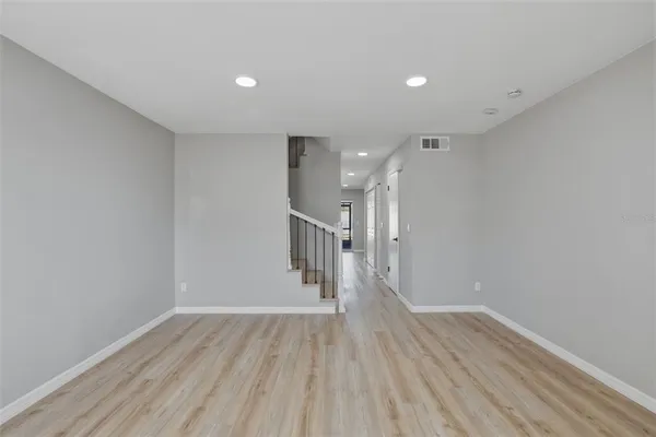 a view of empty room with wooden floor