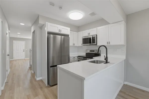 a kitchen with stainless steel appliances a refrigerator sink and microwave