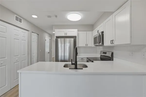 a kitchen with kitchen island a sink stainless steel appliances and cabinets