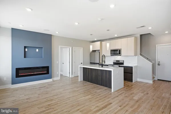 a kitchen with stainless steel appliances a sink cabinets and wooden floor
