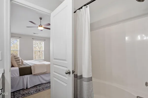 an empty room with a window and a fan