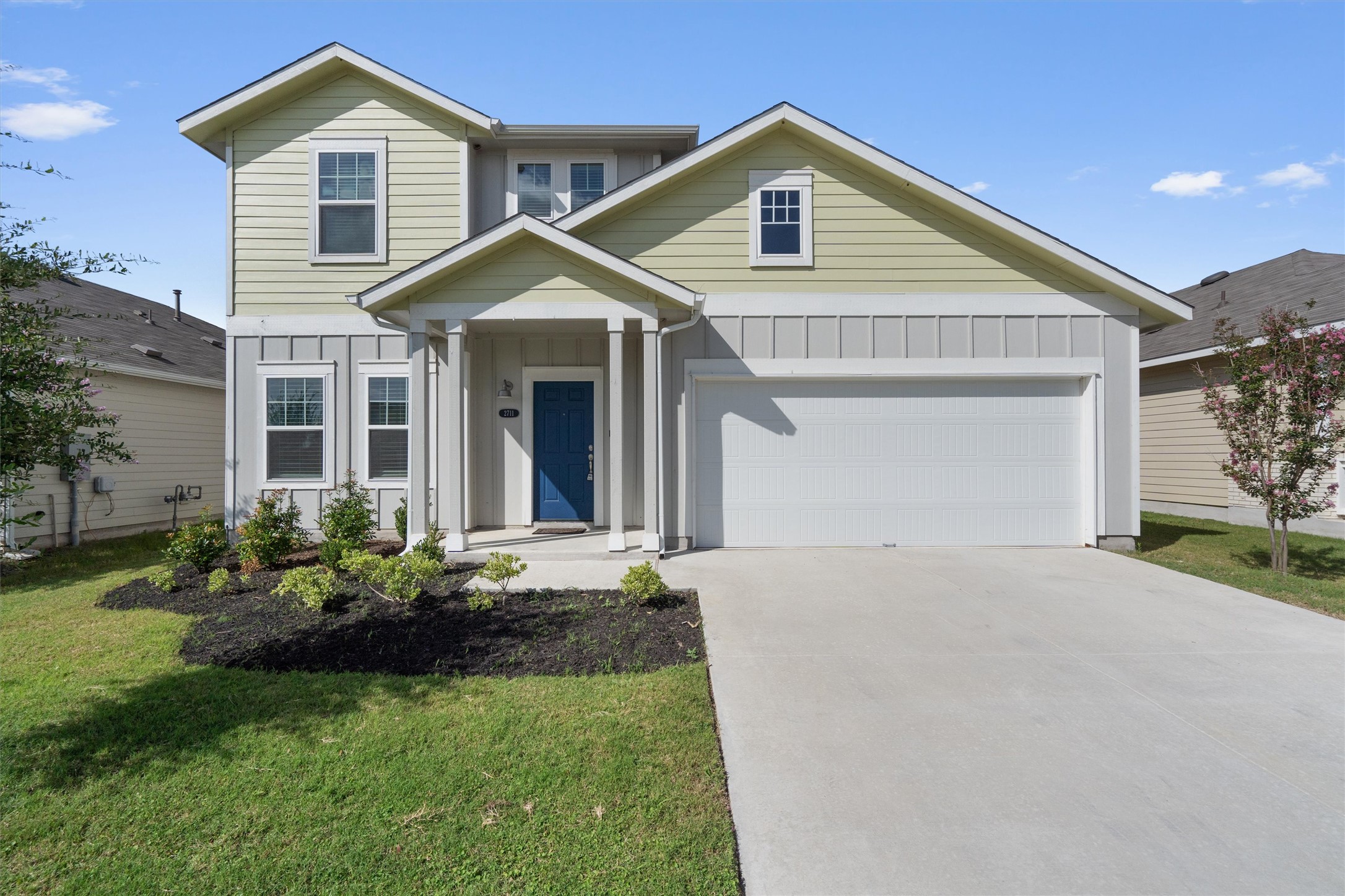 a front view of a house with a yard and garage