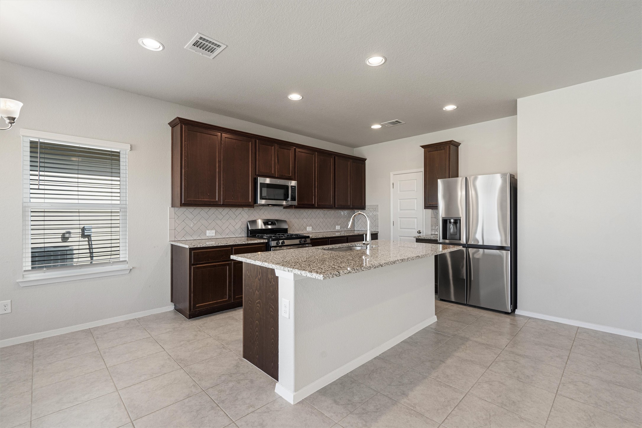 2711 Winding Creek Road Kyle, TX 78640 - Photo 11 of 33 a kitchen with a refrigerator stove top oven a sink and dishwasher