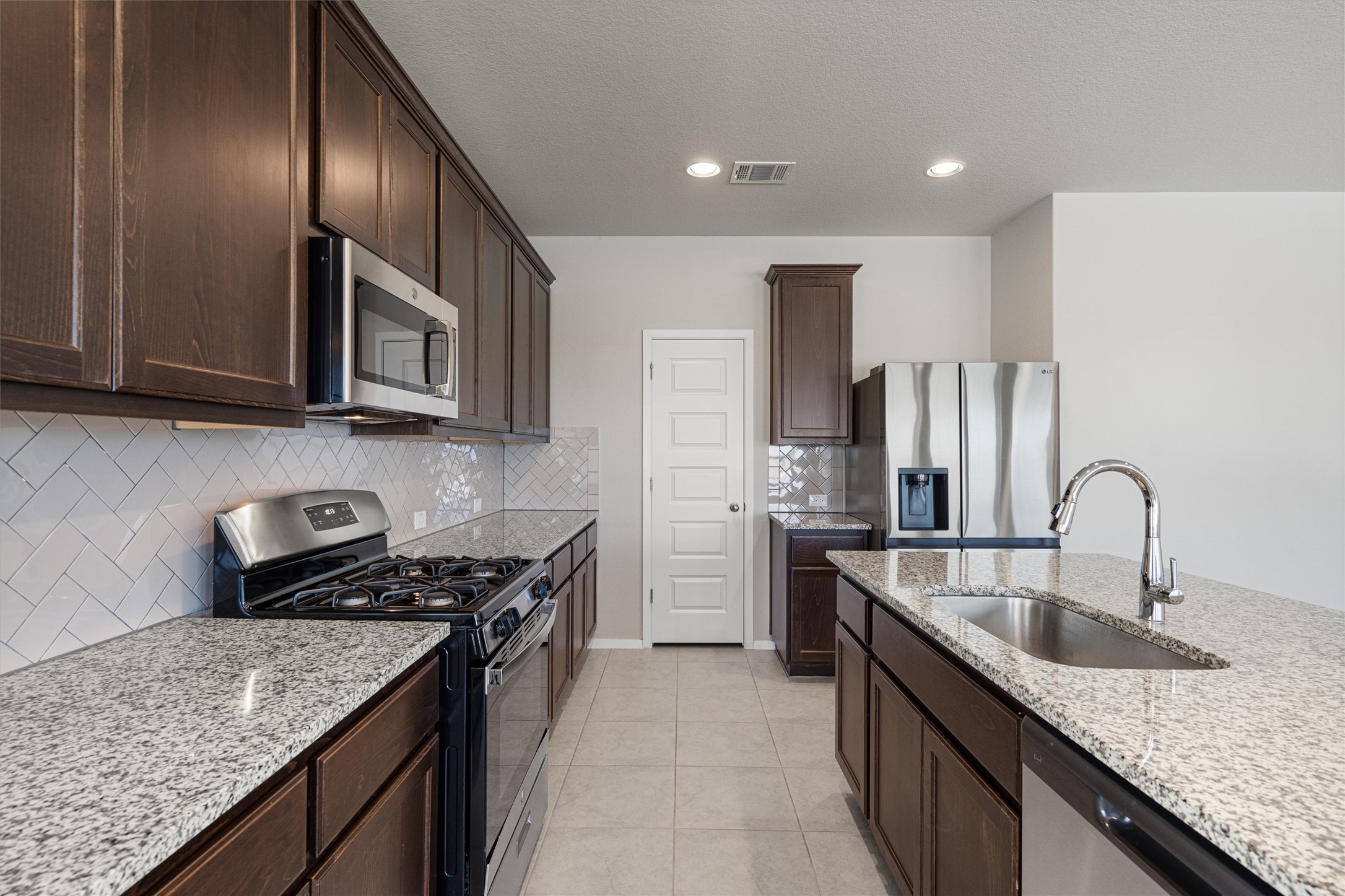 2711 Winding Creek Road Kyle, TX 78640 - Photo 12 of 33 a kitchen with stainless steel appliances granite countertop a sink stove and cabinets