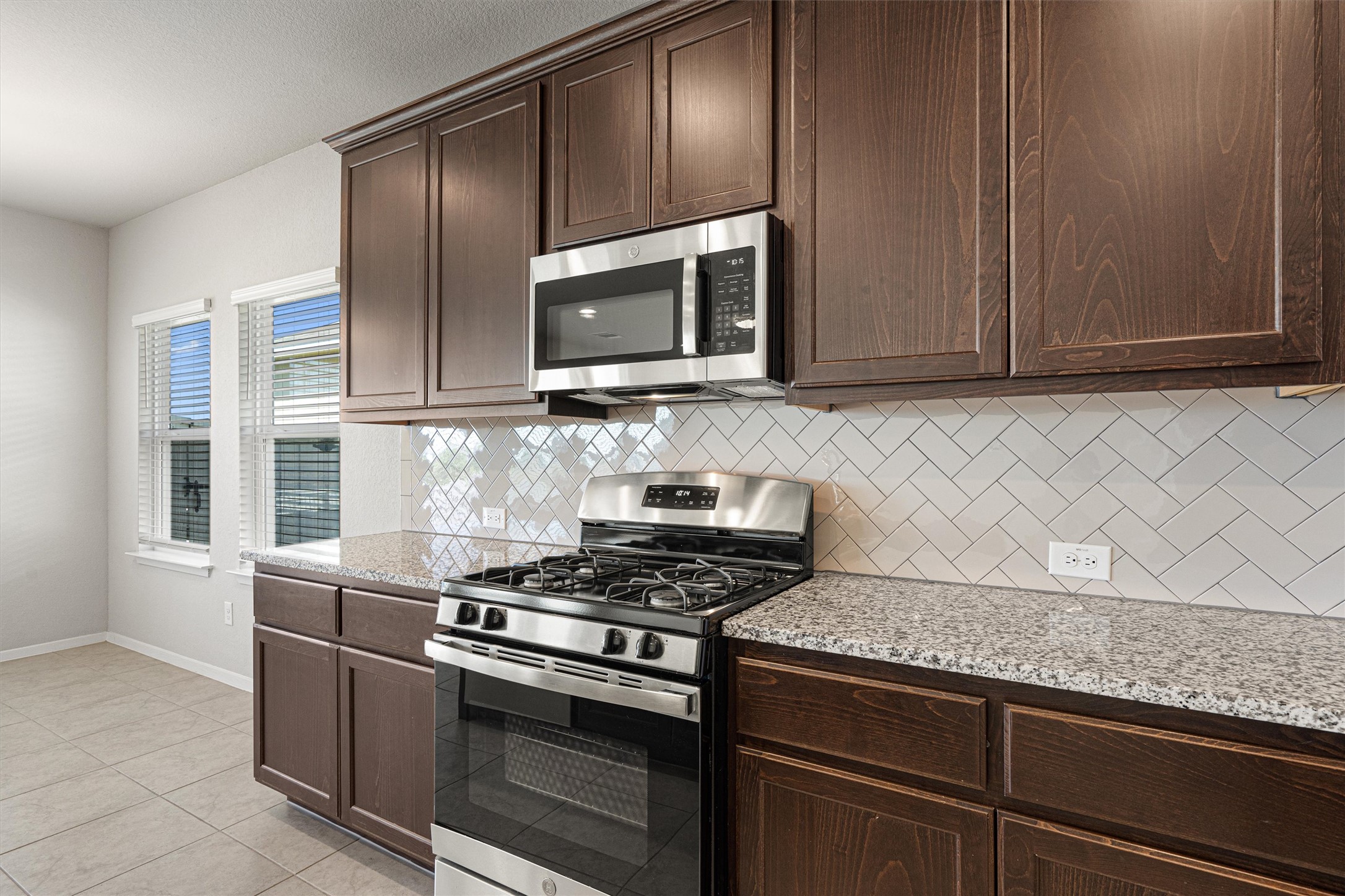 2711 Winding Creek Road Kyle, TX 78640 - Photo 13 of 34 a kitchen with granite countertop cabinets stainless steel appliances and wooden cabinets
