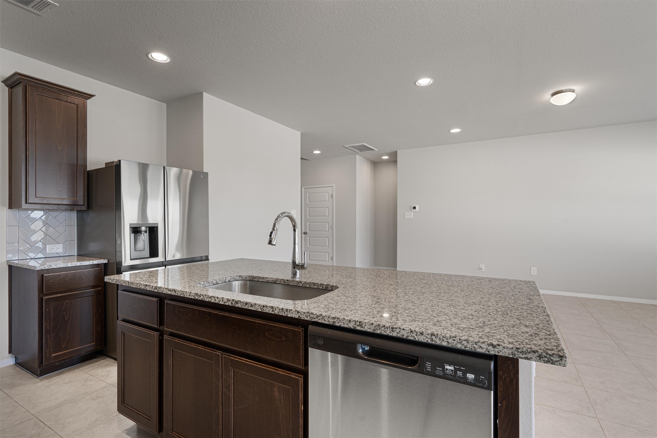 2711 Winding Creek Road Kyle, TX 78640 - Photo 13 of 33 a kitchen with stainless steel appliances granite countertop a sink and a refrigerator
