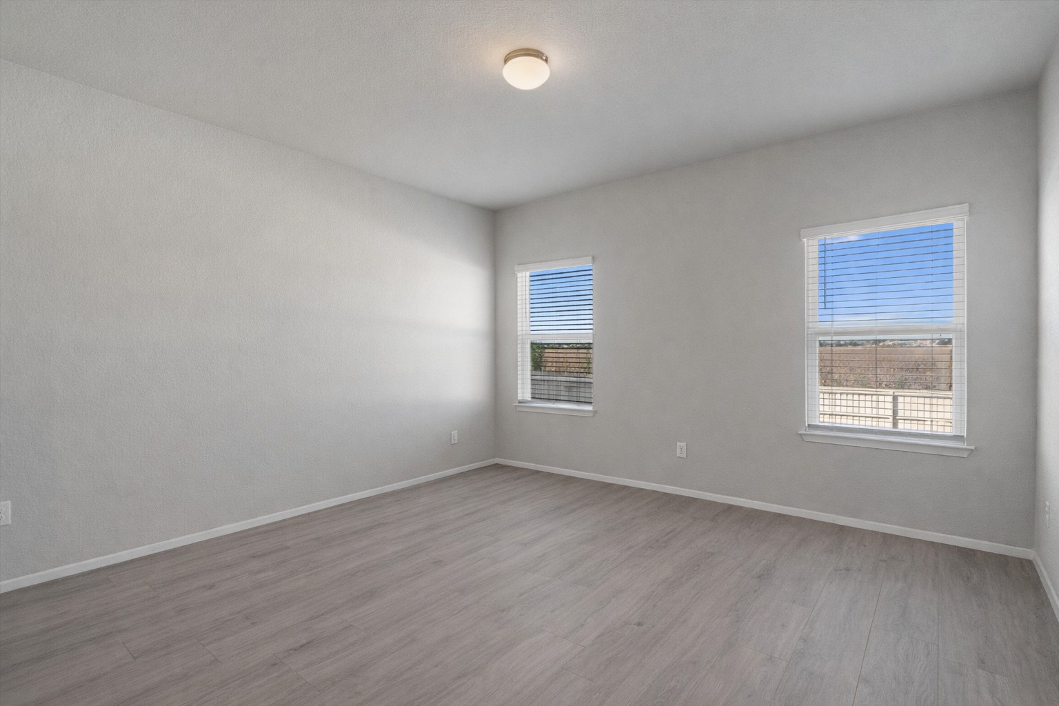 2711 Winding Creek Road Kyle, TX 78640 - Photo 16 of 33 an empty room with wooden floor and windows