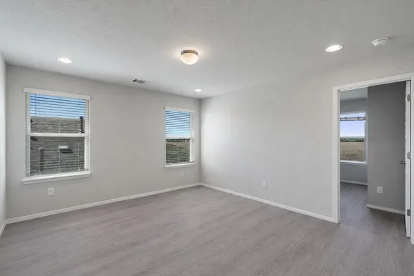 an empty room with a bathroom and a window