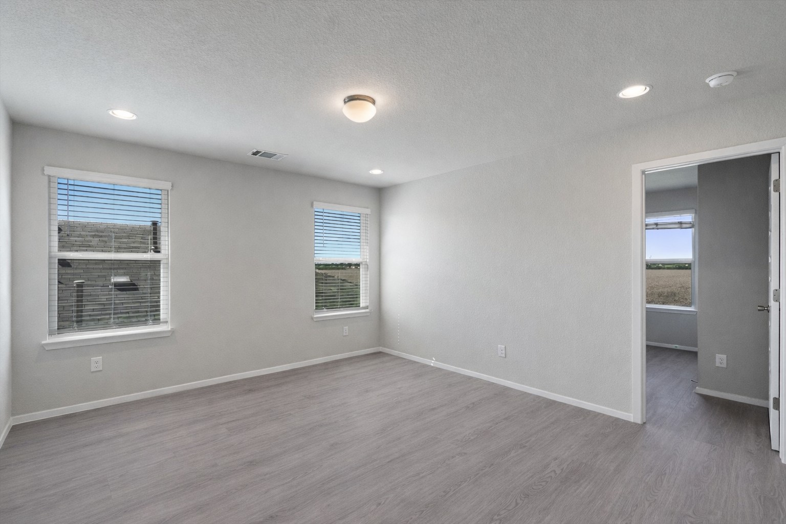 2711 Winding Creek Road Kyle, TX 78640 - Photo 24 of 33 a view of an empty room with a window and wooden floor