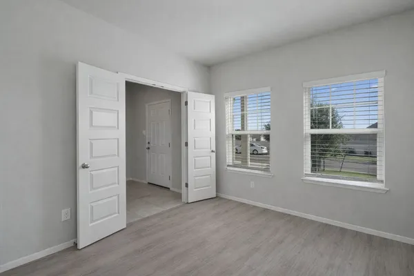 an empty room with windows and closet