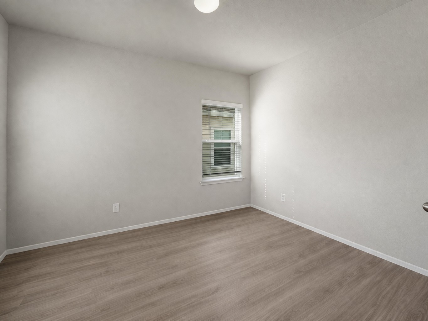 2711 Winding Creek Road Kyle, TX 78640 - Photo 5 of 33 a view of an empty room with wooden floor and a window