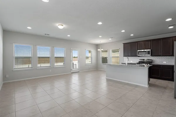 a large kitchen with granite countertop a large counter top stainless steel appliances and cabinets