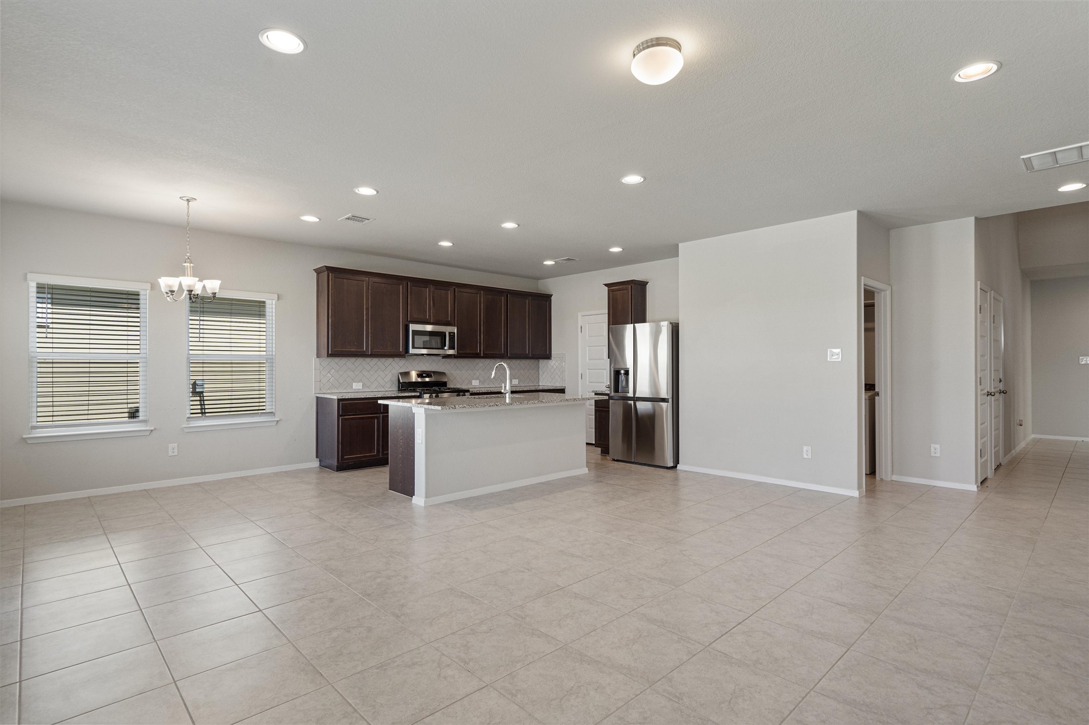 2711 Winding Creek Road Kyle, TX 78640 - Photo 33 of 33 a kitchen with stainless steel appliances kitchen island granite countertop a refrigerator and a sink
