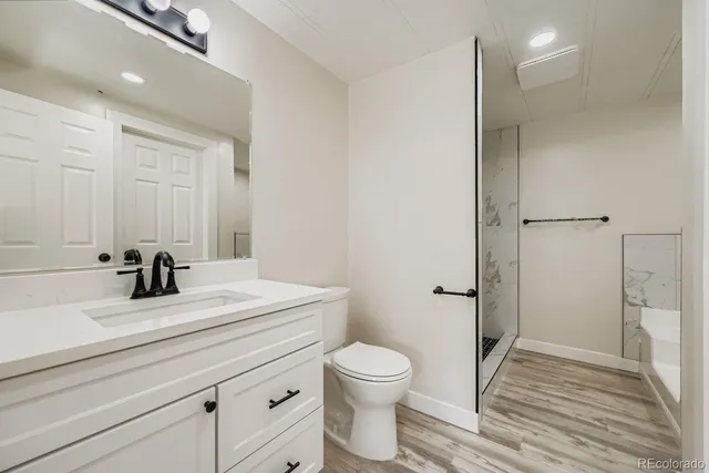 a bathroom with a sink a toilet and shower