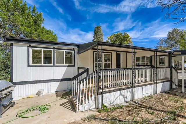 a view of a house with a small yard and wooden fence
