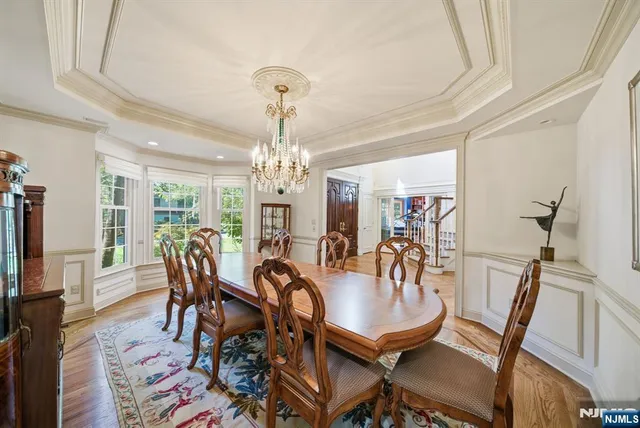 a view of a dining room with furniture a chandelier and wooden floor