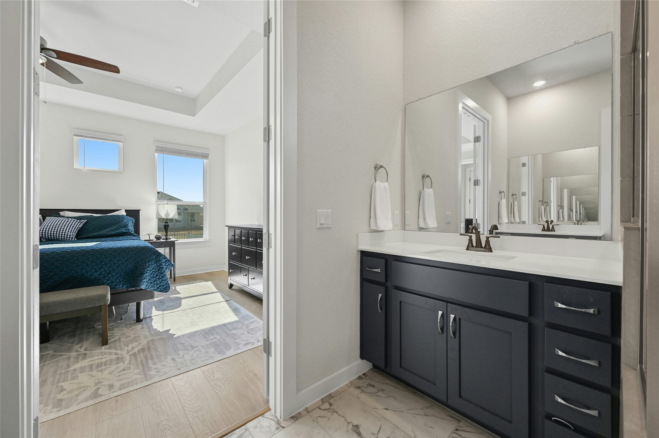 916 Leaning Oak Lane Georgetown, TX 78628 - Photo 16 of 32 Ensuite bathroom with vanity, light marble finish flooring, and a ceiling fan