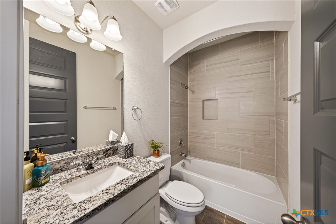 361 Misty Sails Cibolo, TX 78108 - Photo 12 of 48 a bathroom with a granite countertop sink a toilet and bathtub