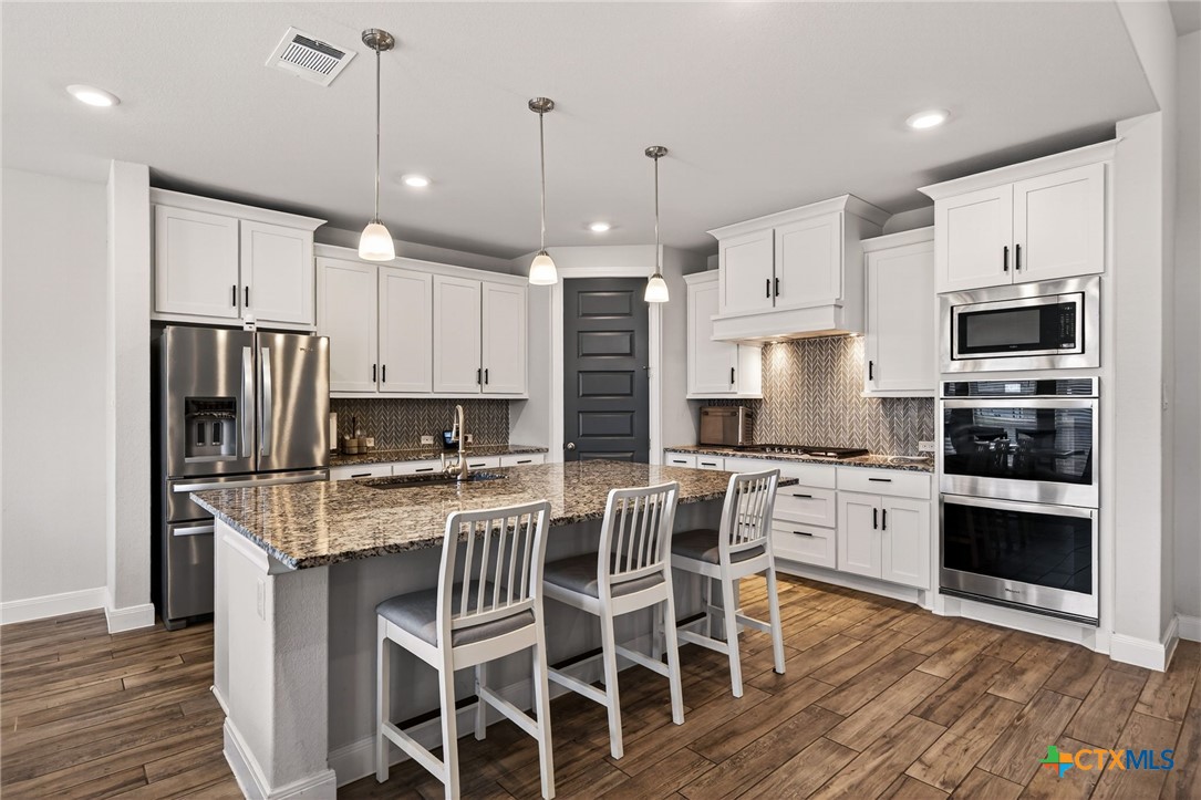 361 Misty Sails Cibolo, TX 78108 - Photo 20 of 48 a kitchen with kitchen island granite countertop a center island stainless steel appliances and cabinets