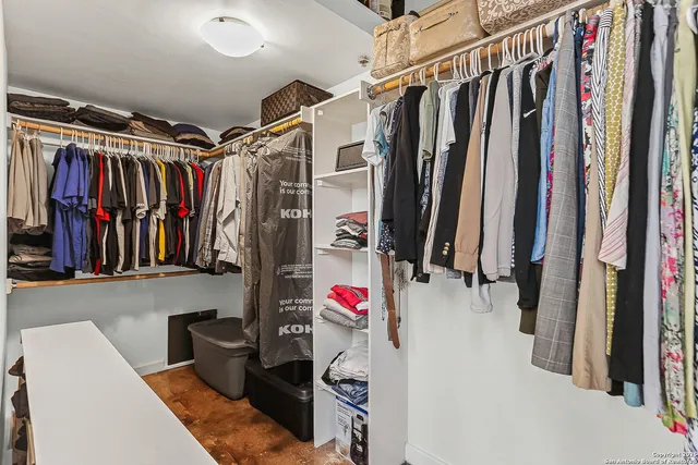 a view of walk in closet with clothes and shoes