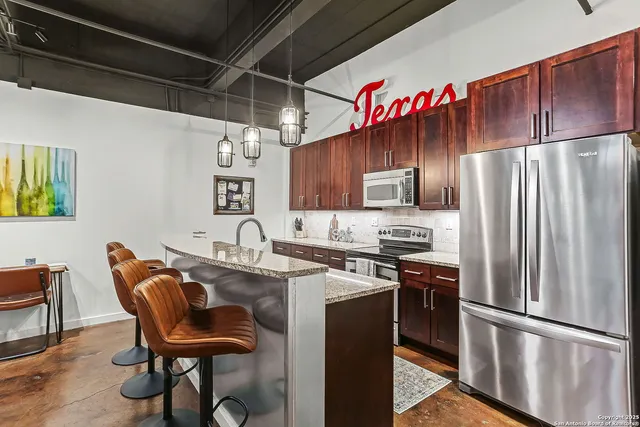 a kitchen with granite countertop a sink stainless steel appliances and cabinets