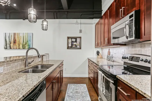 a kitchen with stainless steel appliances granite countertop a sink stove and cabinets