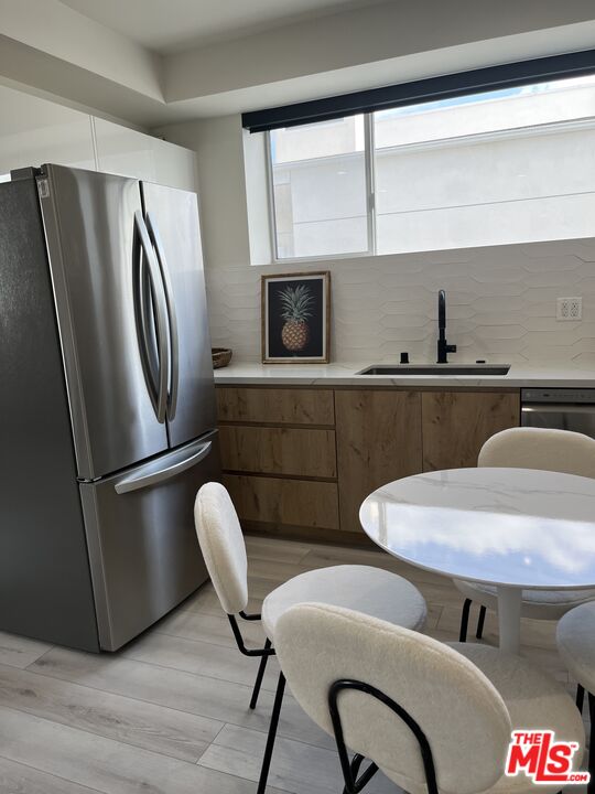 124 South Croft Avenue, Unit 403 Los Angeles, CA 90048 - Photo 15 of 31 a kitchen with stainless steel appliances granite countertop a refrigerator a sink a stove and a dining table