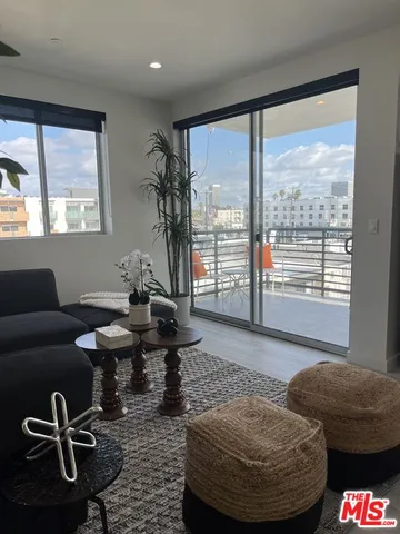 a living room with furniture and a floor to ceiling window