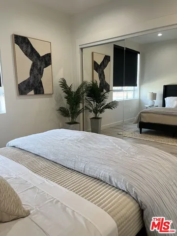 a bedroom with a bed and wooden floor