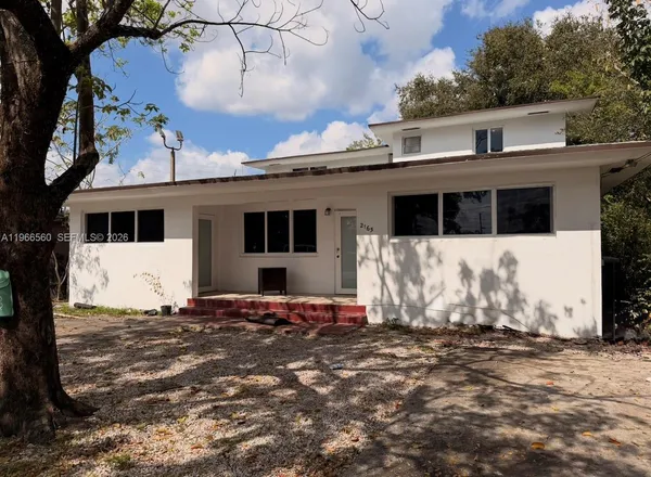 a view of a house with a large tree