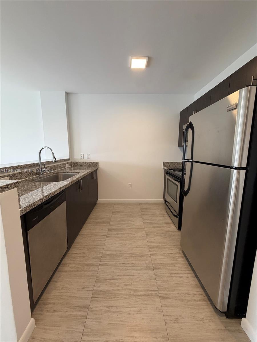 1801 Southwest 32nd Avenue, Unit 704 Miami, FL 33145 - Photo 3 of 18 a view of a kitchen with a sink and a refrigerator