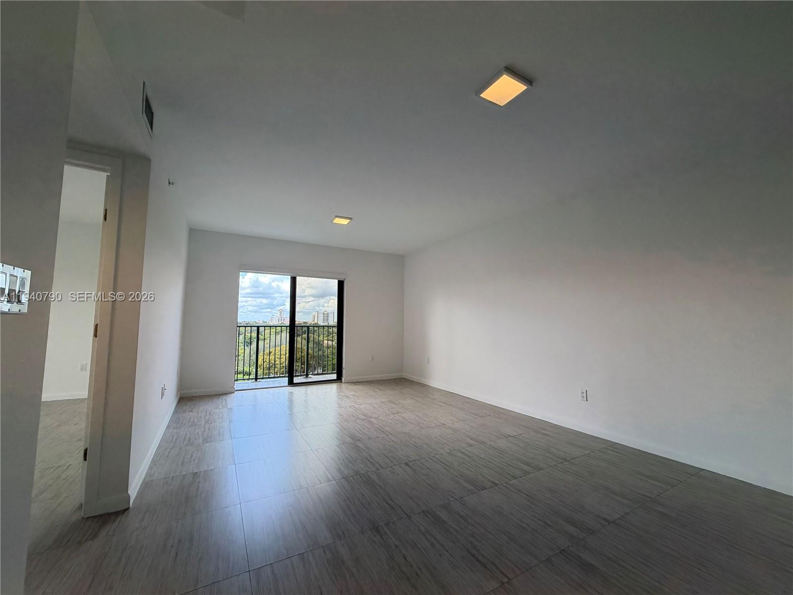 1801 Southwest 32nd Avenue, Unit 704 Miami, FL 33145 - Photo 5 of 18 an empty room with wooden floor and windows