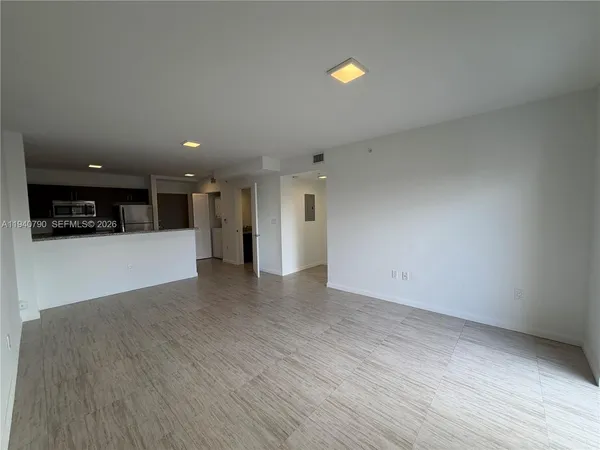 a view of a kitchen with a refrigerator and a stove top oven