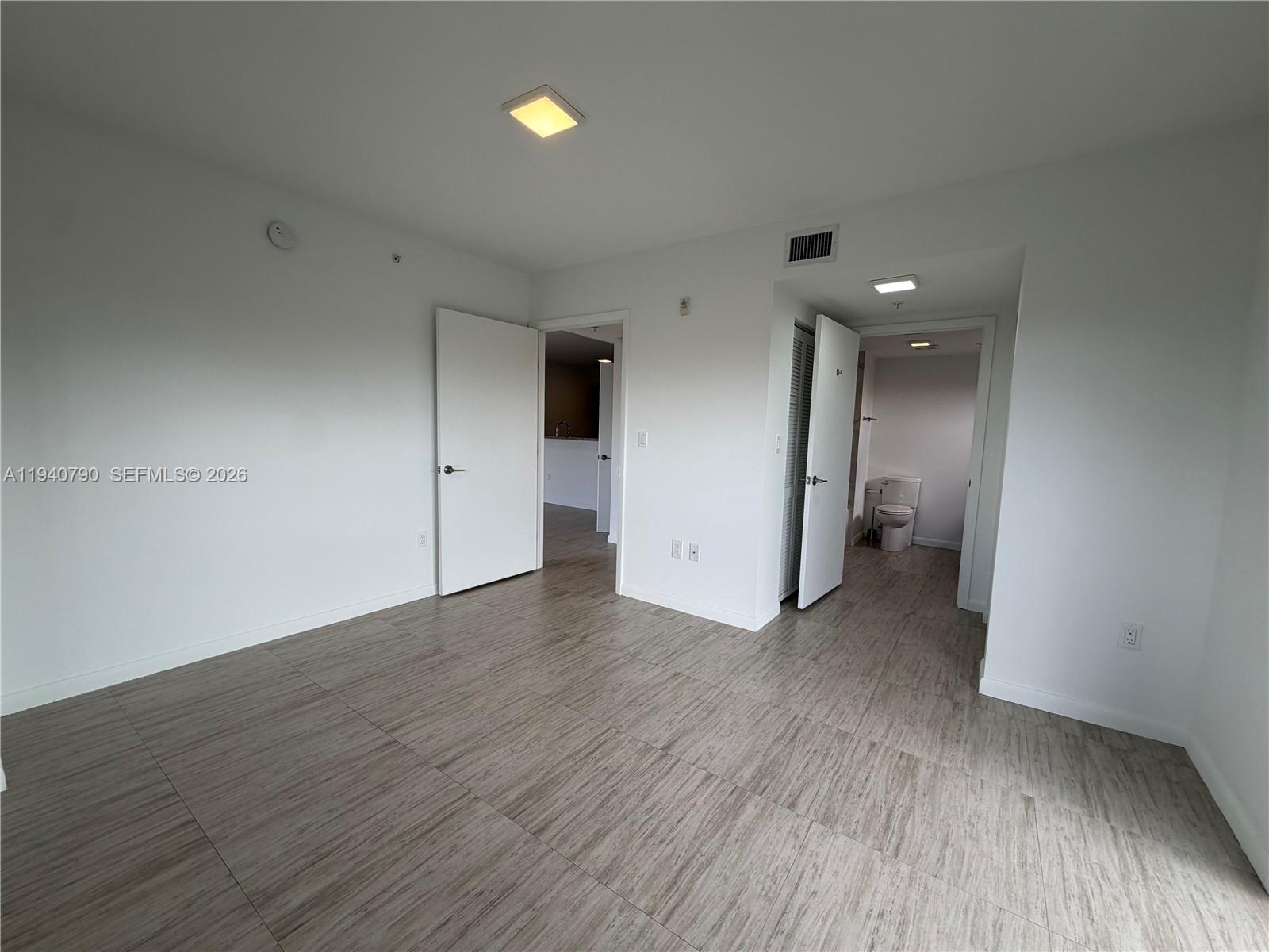 1801 Southwest 32nd Avenue, Unit 704 Miami, FL 33145 - Photo 9 of 18 an empty room with wooden floor and windows