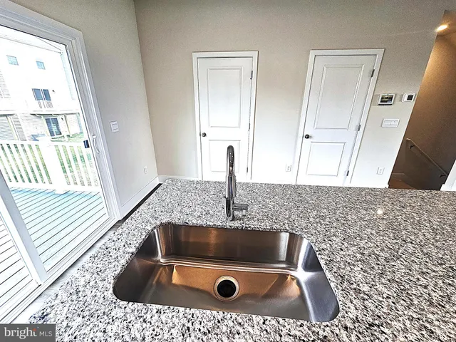 a kitchen with stainless steel appliances a microwave a sink dishwasher a refrigerator and cabinets with wooden floor