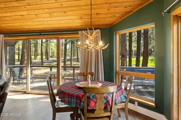 a view of a dining room with furniture large windows and wooden floor