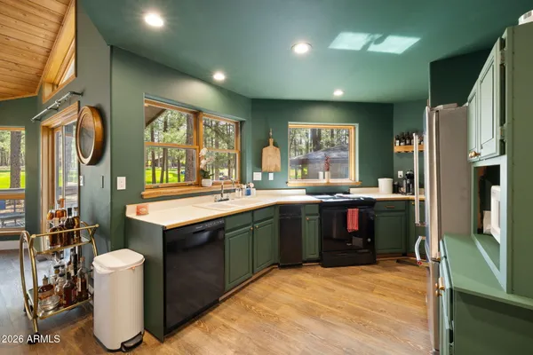 a kitchen with kitchen island granite countertop wooden cabinets a sink a window and stainless steel appliances