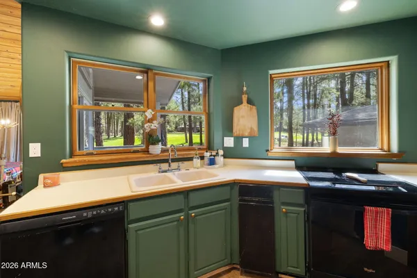 a kitchen with a sink and large windows