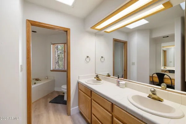 a en suite bathroom with a double vanity sink a mirror and a toilet