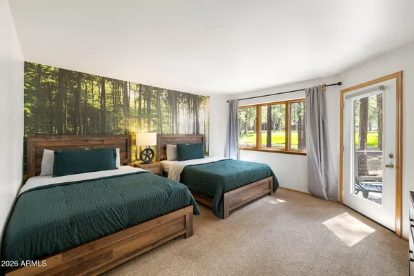 a bedroom with two beds and large window
