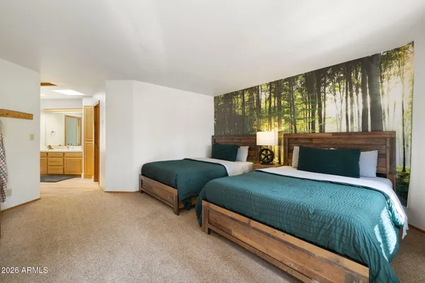 a bedroom with a bed and large windows