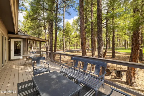 a view of a patio with table and chairs with wooden floor and fence