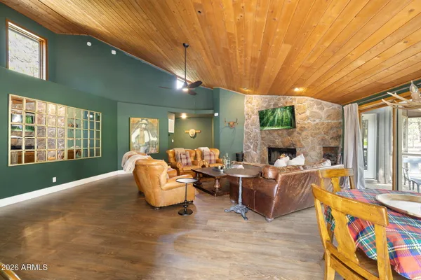 a living room with furniture a fireplace and a floor to ceiling window