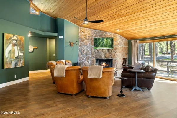 a living room with furniture a fireplace and a floor to ceiling window