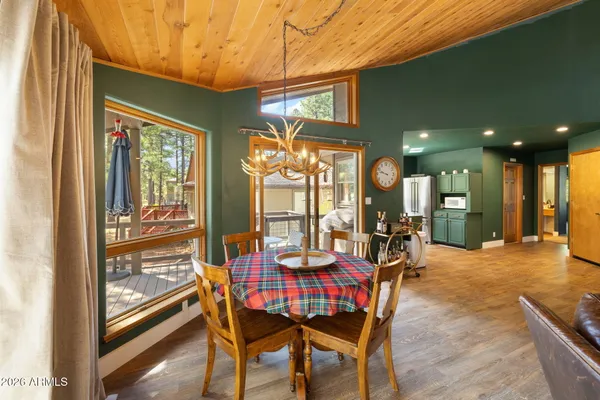a dining room with furniture a chandelier and wooden floor